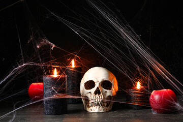 Composition with different burning candles, skull and web for Halloween celebration on black background