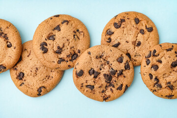 Tasty cookies with chocolate chips on blue background