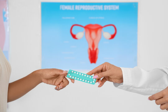 Female gynecologist giving contraceptive pills to patient in clinic, closeup