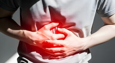 Man suffering from stomach pain, holding his belly with both hands in agony