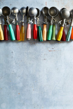 Vintage ice cream scoops with colorful handles, overhead food styling props