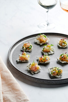 Canape platter of snapper tartare with pineapple, kaffir lime salsa, coconut & green chilli dressing on black sesame rice wafers