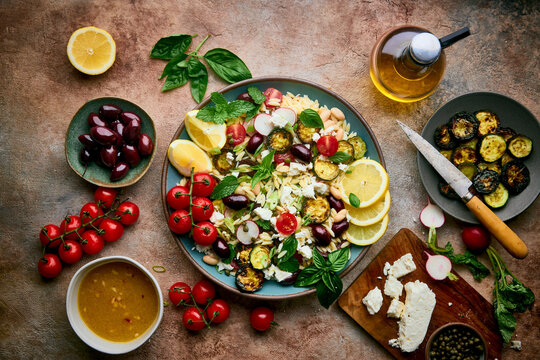 Mediterranean Salad in a bowl, surrounded by ingredients