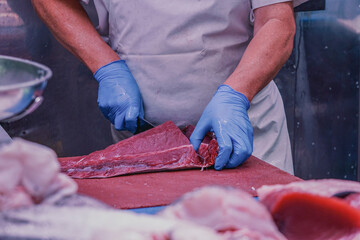 Fishmonger Cutting Fresh Tuna at Seafood Market