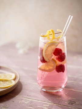 Raspberry lemonade served with ice, lemon slices and fresh raspberries