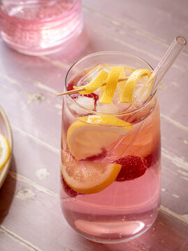 Raspberry lemonade served with ice, lemon slices and fresh raspberries