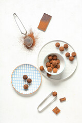 Plates with tasty chocolate truffles on white background