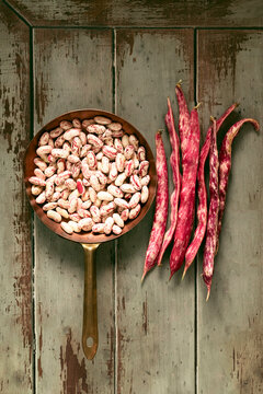 flat lay of fresh borlotti beans in copper pan some of them still whole, ready to be cooked