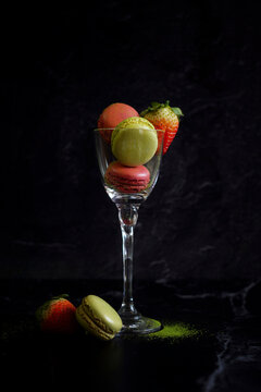 Japanese Matcha and Strawberry Macarons on Black Marble Background.