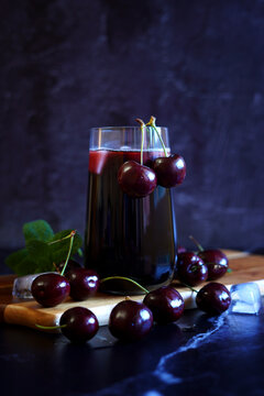 Pure Black Cherry Juice on Dark Background.