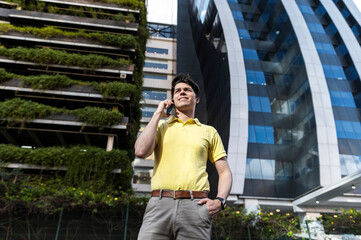 Confident entrepreneur communicating on smartphone in sustainable business district