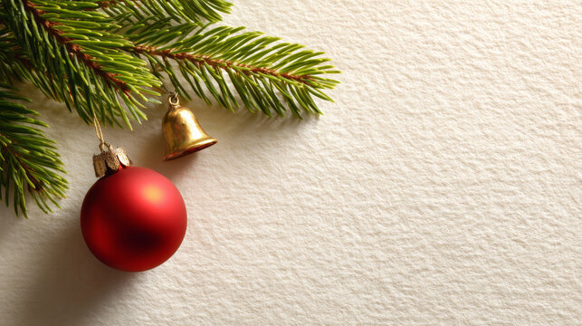 Close-up of green pine branches with red Christmas ornament and small golden bell on textured beige background