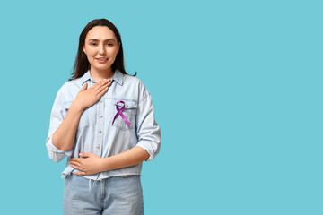 Pretty young woman with purple ribbon on blue background. Pancreatic cancer awareness concept