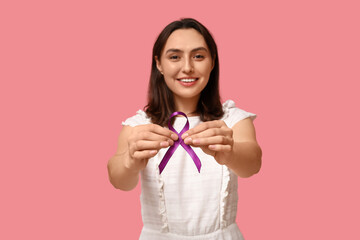 Pretty young woman with purple ribbon on pink background. Pancreatic cancer awareness concept