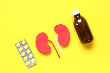 Paper human kidneys and medicines on yellow background