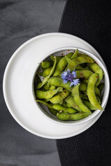 Green peas restaurant dish in a white plate on a dark background isolated