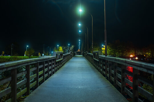 Night pedestrian bridge near Malbork with glowing streetlamps