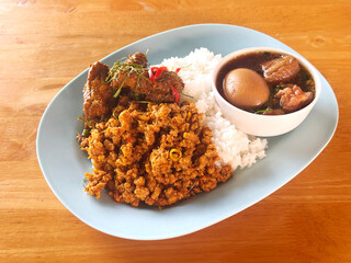 Thai-style meal featuring various traditional dishes served over rice