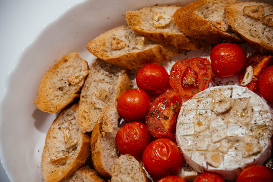 Camembert cheese baked with tomatoes and baguette, herbs and garlic. An excellent appetizer for wine. View from above. 