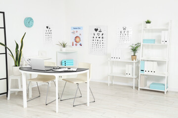 Interior of oculist's office with workplace and eye test charts