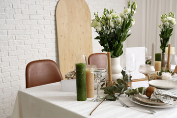 Beautiful table setting with eustoma flowers and eucalyptus for wedding celebration in room