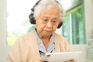 Asian senior woman patient happy to use earphone to listen relax music.