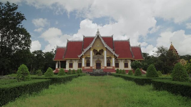 Stunning 4K video of Phu Pha Moei Temple in Mukdahan, Thailand. View of front lawn, green grass, and traditional Buddhist temple architecture in natural light.