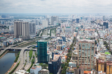 Aerial cityscape of Ho Chi Minh City ( Saigon ), Vietnam, showcasing modern skyscrapers, dense urban layout, and river. Biggest Vietnamese metropolis at south part of county on a bright sunny day.