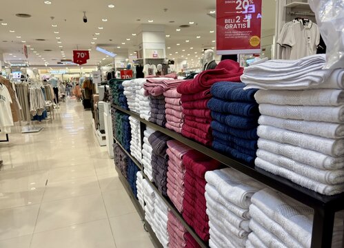 Vibrant towel display enticing shoppers with comfort and style in a modern department store setting, showcasing quality and value with diverse colors