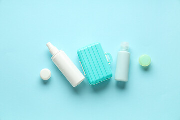 Composition with travel cosmetic kit and mini suitcase on color background