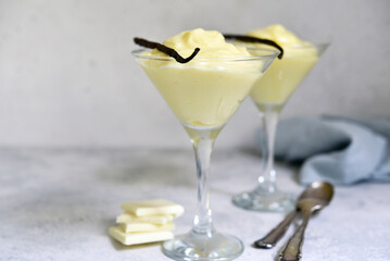 Delicious vanilla pudding with white chocolate in a glasses .