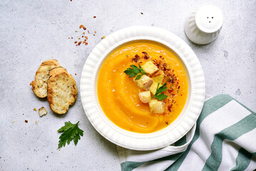 Delicious pumpkin soup with croutons in white bowl . Top view with copy space.