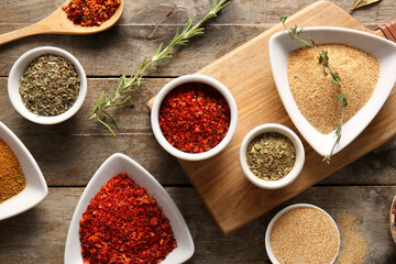 Composition with bowls of different aromatic spices on wooden background