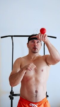 person practicing quick reflex, individual doing reaction exercises comfortably, participant engaging in fast response training session, person executing dynamic speed drills with elastic ball