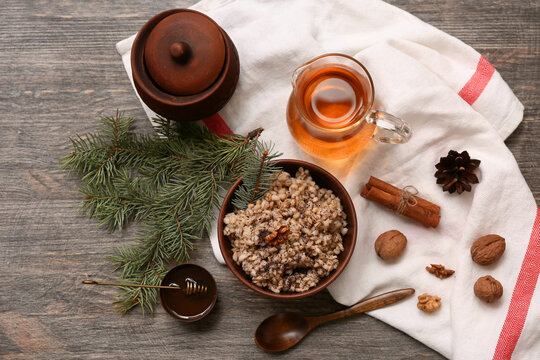 Bowl of traditional Ukrainian Kutya dish with Christmas tree branches and jug of uzvar on wooden background