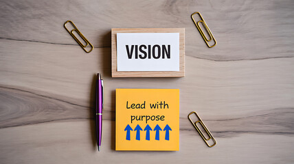 Vision and lead with purpose motivational messages written on wooden blocks and sticky notes with arrows and stationery on a light wood grain desk representing core business strategy and future goals.