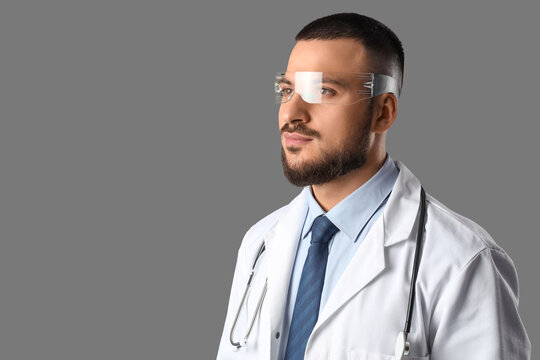 Male doctor in AR glasses on grey background