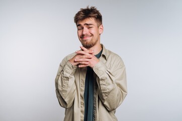 Young man with playful expression displays mischief in a studio setting during daylight hours