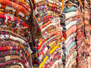 Istanbul, Turkey - August 28, 2025: Close up Stack of colorful handmade Turkish carpets and kilims in a traditional rug store