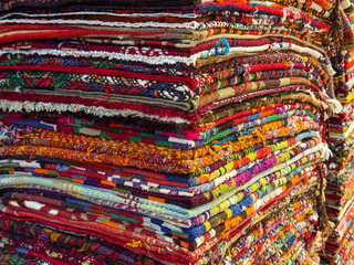 Istanbul, Turkey - August 28, 2025: Neatly stacked colorful handmade Turkish carpets on display at a bazaar