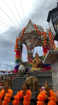 Golden Phra Phrom Statue at Colorful Thai Shrine under Cloudy Sky at PIK 2