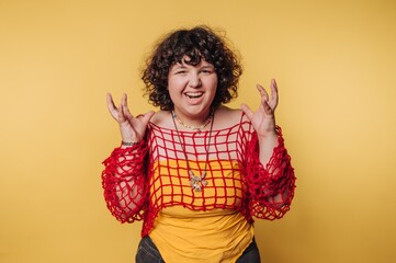 Colorful expression of joy in artistic outfit against a vibrant yellow background