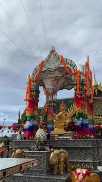 Golden Phra Phrom Statue at Colorful Thai Shrine under Cloudy Sky at PIK 2