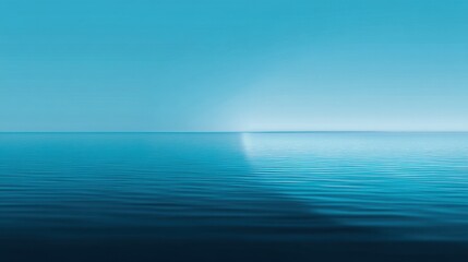 Obraz premium Tranquil Seascape with Soft Blue Tones and Gentle Ripples Under a Clear Sky at Sunrise or Sunset Capturing the Essence of Serenity and Calmness