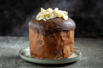 Gourmet Panettone with Dark Chocolate Glaze and White Chocolate Shavings on Dark Background