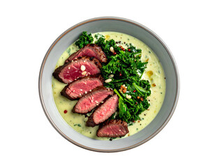 Sliced seared steak, kale, and pine nuts in a creamy sauce, served in a bowl