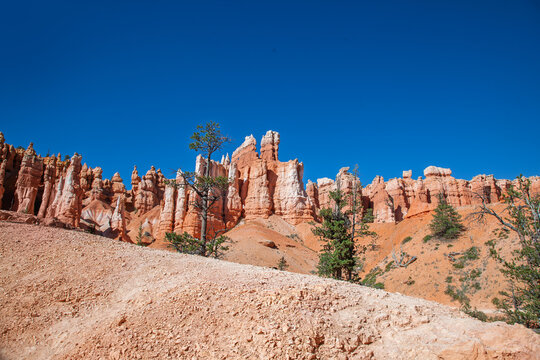 Landscape of red rock formations under clear blue sky. Bryce Canyon, Utah, USA - Powered by Adobe
