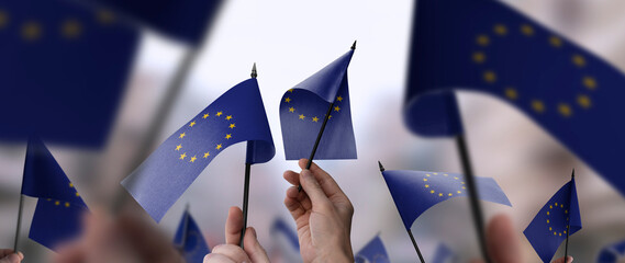 European Union flags in their hands on a blurred urban background