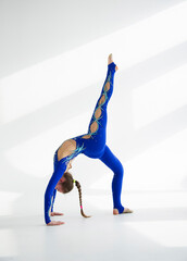 young woman in blue acrobatic suit doing yoga exercise.  Sport  conception