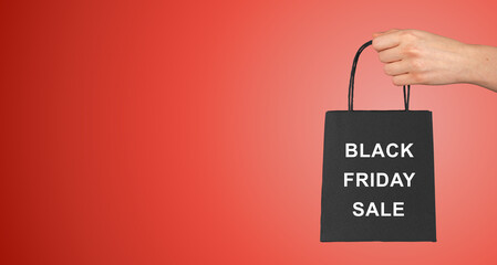 Hand holding, giving, presenting small gift bag, paper packet, pack with handles, kraft package